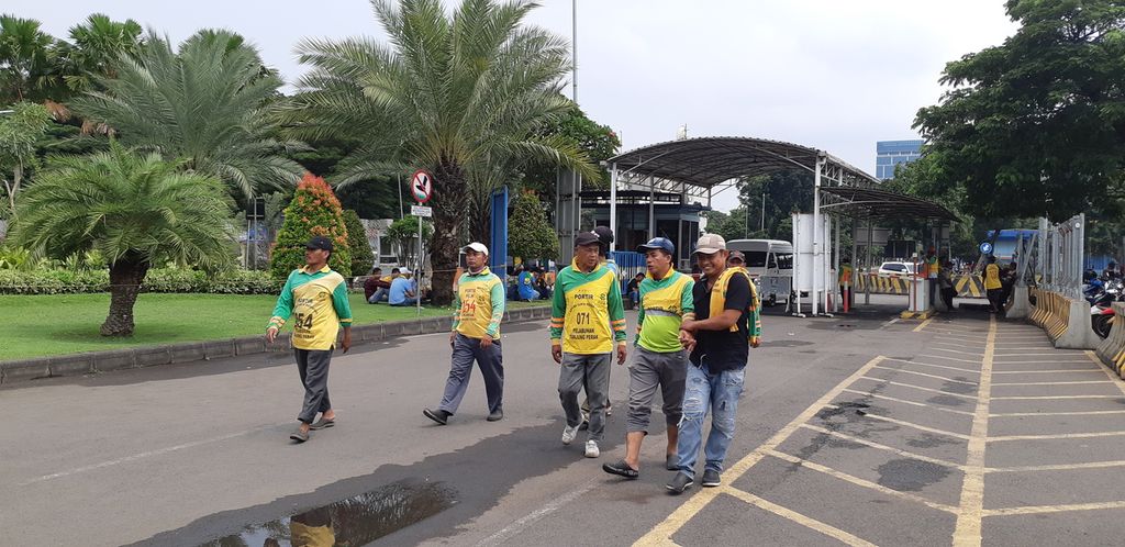 Beberapa kuli angkut di Gapura Surya Tanjung Perak, Surabaya, bersiap menyambut kedatangan penumpang Kapal Motor Labobar, Rabu (8/3/2023). Terdapat 360 kuli angkut yang beroperasi setiap hari. Mereka menawarkan jasa layanan angkut barang dengan upah Rp 200.000 hingga Rp 250.000 per penumpang 