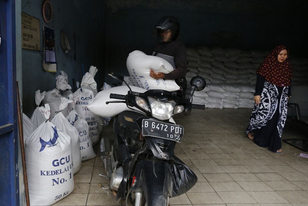 Perajin tahu berbelanja kedelai impor di gudang Primkopti Jakarta Selatan di kawasan Kebayoran Lama, Minggu (29/1/2023). Telah masuknya kedelai yang diimpor Bulog menjadikan harganya mulai turun di pasaran. Saat ini harga kedelai di tempat tersebut Rp 12.300 per kilogram (kg), pemerintah menargetkan harga kedelai impor dapat berada di kisaran Rp 11.000-Rp 12.000 per kg.