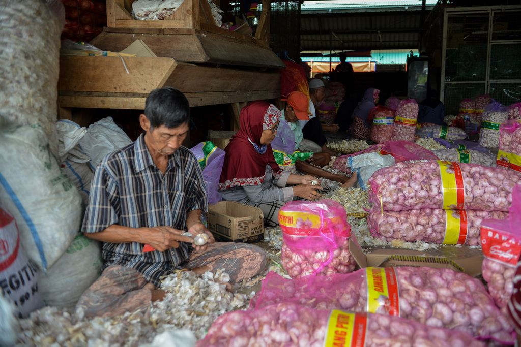 Deretan buruh pengupas bawang putih saat menyelesaikan pekerjaannya di Pasar Induk Modern Cikopo, Purwakarta, Jawa Barat, Senin (1/5/2023).