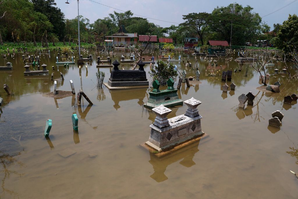 Banjir yang turut merendam makam selain permukiman dan fasilitas publik lainnya di Desa Karangrowo, Kecamatan Undaan, Kabupaten Kudus, Jawa Tengah, Jumat (17/3/2023). 