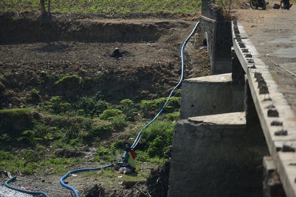 Petani menghidupkan mesin penyedot air di sebelah jembatan akses menuju bekas pemukiman Dusun Sarean, Desa Genengsari, Kemusu, Boyolali, Jawa Tengah, Jumat (13/9/2019). Jembatan tersebut terendam air Waduk Kedungombo saat musim hujan. Warga dusun itu diikutsertakan dalam program transmigrasi ke sejumlah wilayah di Pulau Sumatera menjelang tahun 1989 seiring awal mula penggenangan air Waduk Kedungombo. Pengoperasian Waduk Kedungombo menenggelamkan 37 desa di Kabupaten Sragen, Boyolali, dan Grobogan.