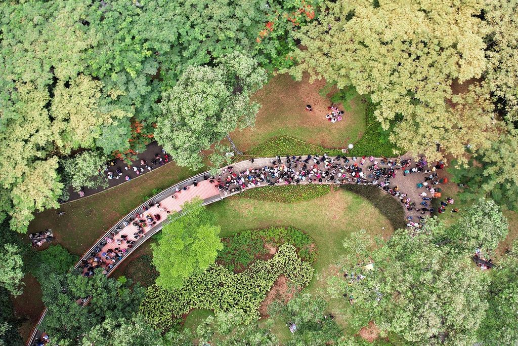 Pengunjung antre untuk menaiki Infinity Link Bridge saat berwisata di Tebet Eco Park, Tebet, Jakarta, mengisi libur Hari Waisak, Senin (16/5/2022). 