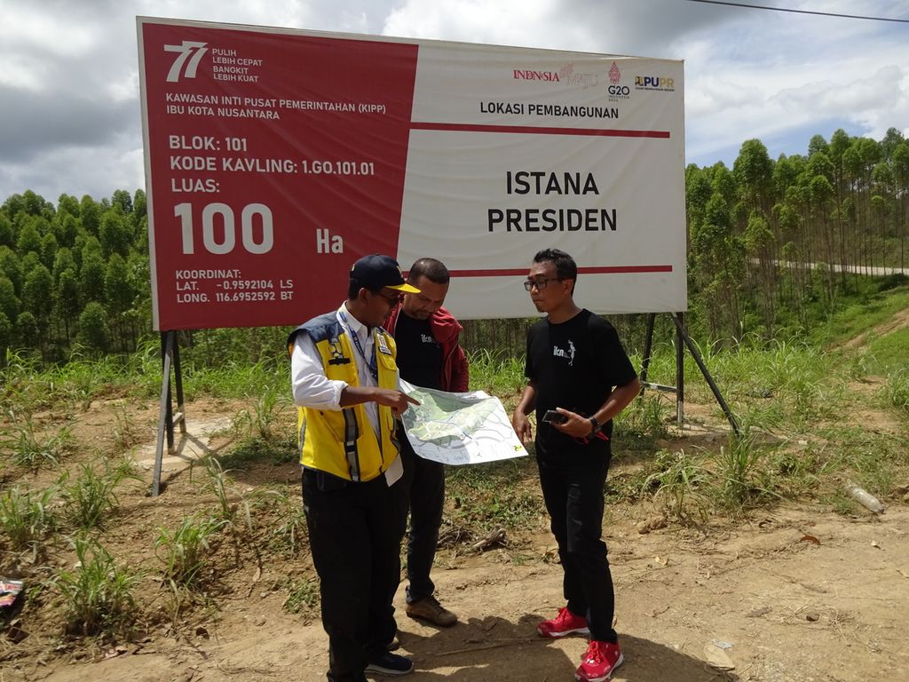 Seorang pegawai Kementerian Pekerjaan Umum dan Perumahan Rakyat menunjukkan peta lokasi rencana pembangunan Kompleks Presiden di depan area kavling Istana Presiden yang menempati lahan seluas 100 hektar di Ibu Kota Negara Nusantara, Kalimantan Timur, Sabtu (5/11/2022).