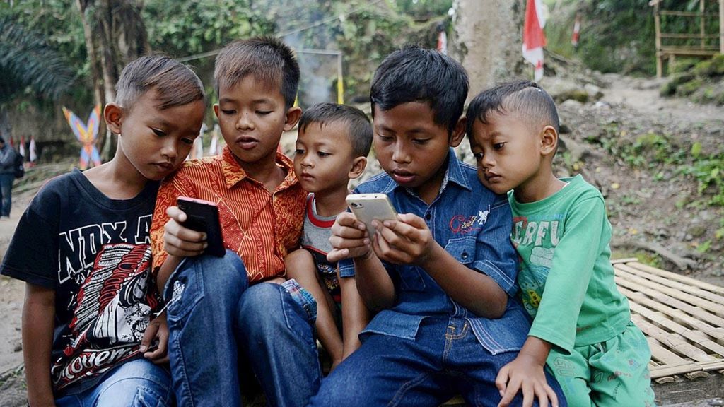 Anak-anak menggunakan gawai di Desa Socokangsi, Kecamatan Jatinom, Kabupaten Klaten, Jawa Tengah, Jumat (14/7/2017).