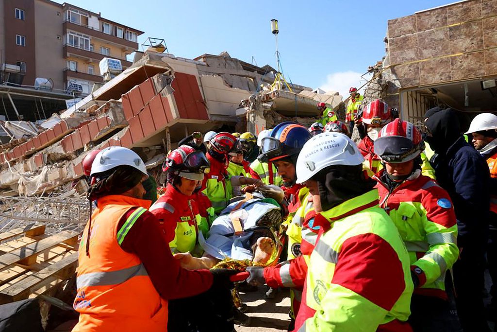 Dalam foto yang diambil pada Jumat (10/2/2023) ini terlihat para anggota tim organisasi spesialis untuk bantuan bencana alam asal Jerman, ISAR, mengevakuasi seorang perempuan dari reruntuhan gedung yang ambruk akibat gempa di Kirikhan, Turki. 