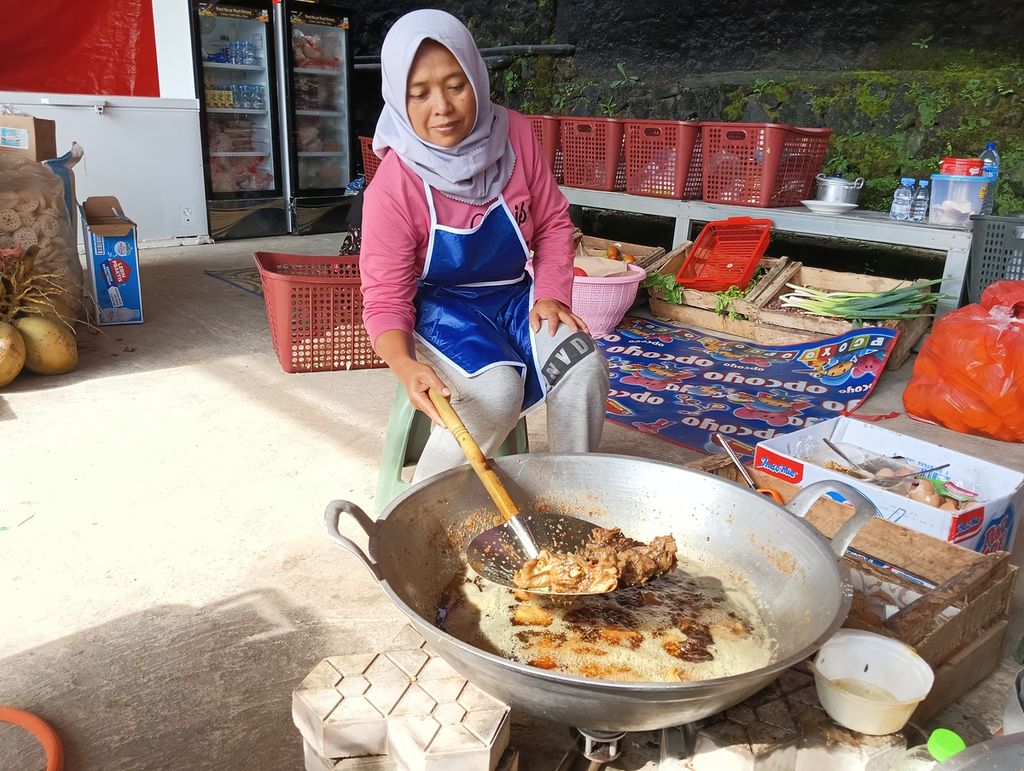 Olis (39), warga Kampung Cimanglid, Desa Cijedil, Cugenang, membantu memasak di dapur umum posko pengungsian Badan Intelijen Negara (BIN), Kamis (8/12/2022). 