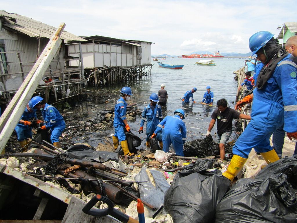 Petugas membersihkan sampah plastik dan limbah oli yang mencemari kawasan pesisir Kecamatan Panjang, Kota Bandar Lampung, Lampung, pada Kamis (10/3/2022).