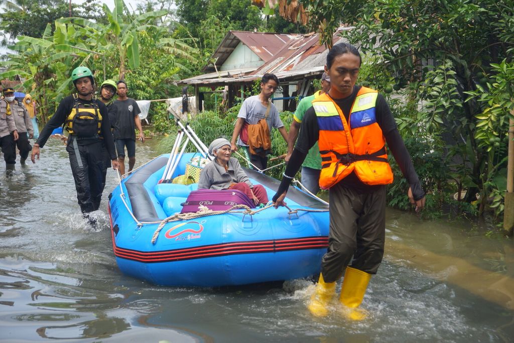 Sukarelawan mengevakuasi warga lansia di tengah banjir yang merendam Desa Nusadadi, Kecamatan Sumpiuh, Banyumas, Jawa Tengah, Jumat (18/3/2022). Sekitar 20 warga mengungsi ke tempat aman.