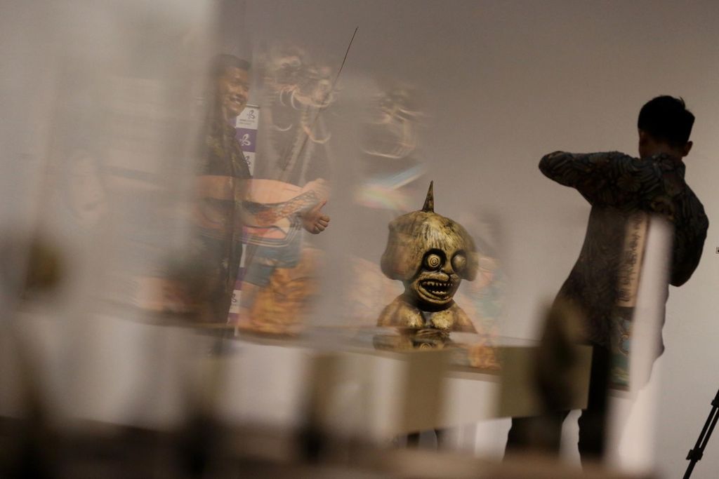 Pengunjung berpose di samping patung hantu Jepang pada pameran Yokai Parade hasil kerja sama antara Bentara Budaya dengan Japan Foundation dan Kedutaan Jepang di Jakarta, Kamis (16/6/2022). Pameran yang menampilkan sejumlah profil hantu monster asal Jepang tersebut akan berlangsung hingga 27 Juni.