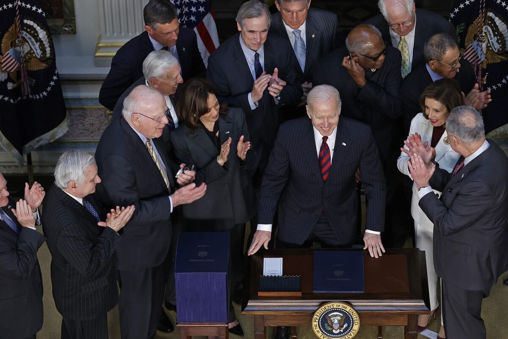 Presiden AS Joe Biden (tengah) mendapat aplaus dari Wakil Presiden Kamala Harris dan para pemimpin Kongres setelah menandatangani Consolidated Appropriations Act di Ruang Traktat India di Gedung Kantor Eksekutif Eisenhower di Washington DC, AS, 15 Maret 2022.  