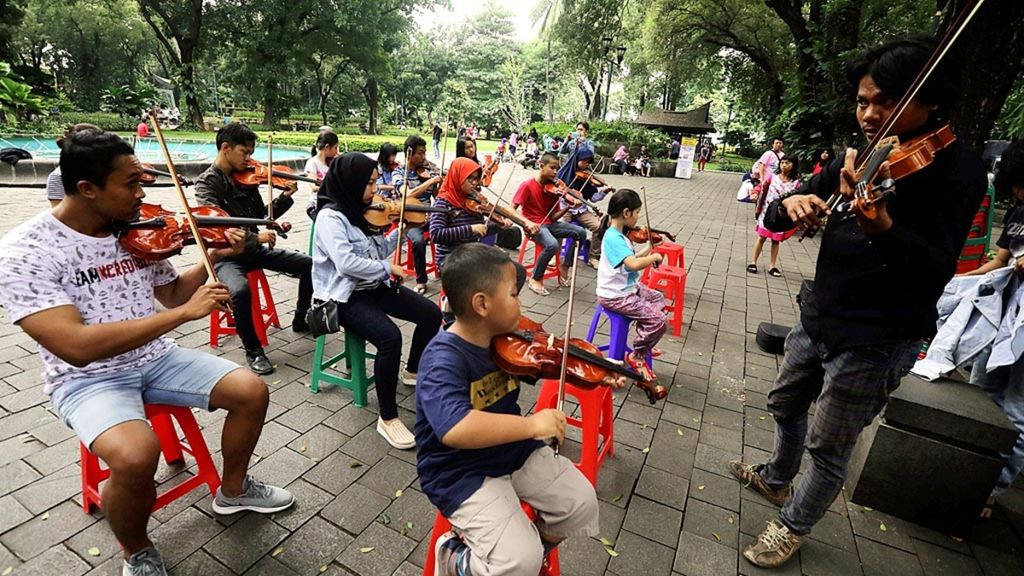 Sejumlah anggota komunitas Taman Suropati Chamber berlatih memainkan biola di Taman Suropati, Menteng, Jakarta Pusat, Minggu (20/1/2019). Taman kota yang nyaman tidak hanya menjadi paru-paru di tengah belantara beton Ibu Kota, tetapi juga dapat menjadi oase bagi warga.