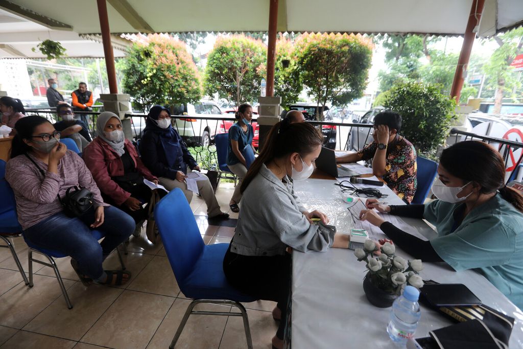 Warga mengantre pemeriksaan kesehatan sebelum menerima vaksin penguat Pfizer di Kantor Kecamatan Senen, Jakarta, Kamis (20/10/2022). 