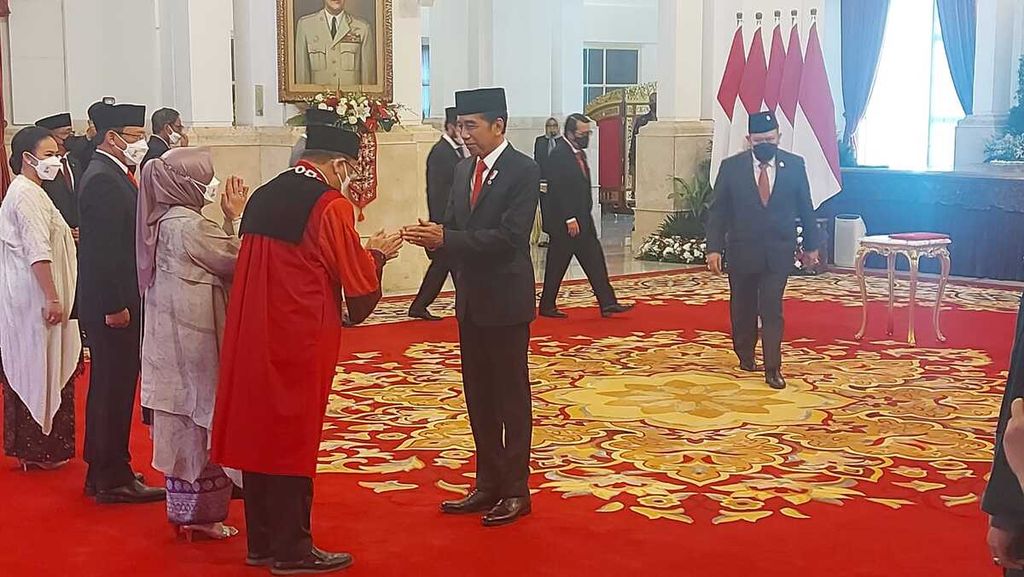 Presiden Joko Widodo memberikan ucapan selamat seusai menyaksikan pengucapan sumpah calon hakim konstitusi M Guntur Hamzah sebagai hakim konstitusi di Istana Negara, Jakarta, pada Rabu, 23 November 2022.