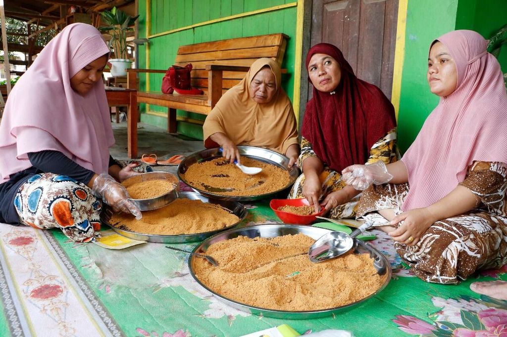 Anggota kelompok perempuan di Samar Kilang, Kecamatan Syiah Utama, Kabupaten Bener Meriah, Aceh, mengolah aren menjadi gula aren serbuk, Selasa (25/1/2022). Selain untuk mendorong ekonomi, pemberdayaan perempuan di kawasan hutan Samar Kilang juga mendorong warga memelihara hutan.