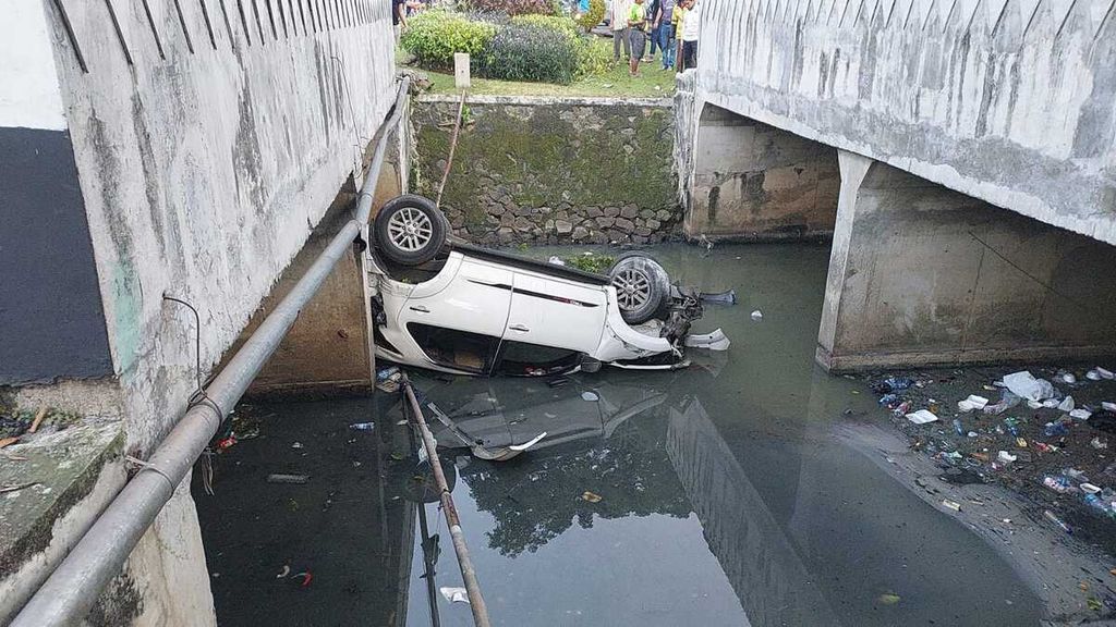 Sebuah mobil tercebur ke saluran air dalam kecelakaan tunggal di Jalan Abdullah Syafei, Tebet, Jakarta Selatan, Kamis (23/6/2022).
