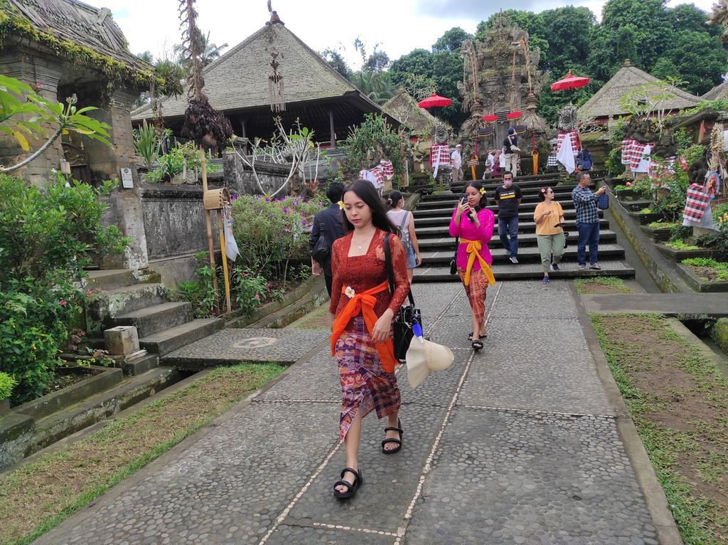 Pengunjung tengah membuat sebuah konten video di Desa Adat Penglipuran, Kabupaten Bangli, Bali, Selasa (28/6/2022). Selain melihat rumah-rumah adat khas Bali, wisatawan juga bisa menyewa baju ada Bali untuk melengkapi momen berada di desa wisata itu.