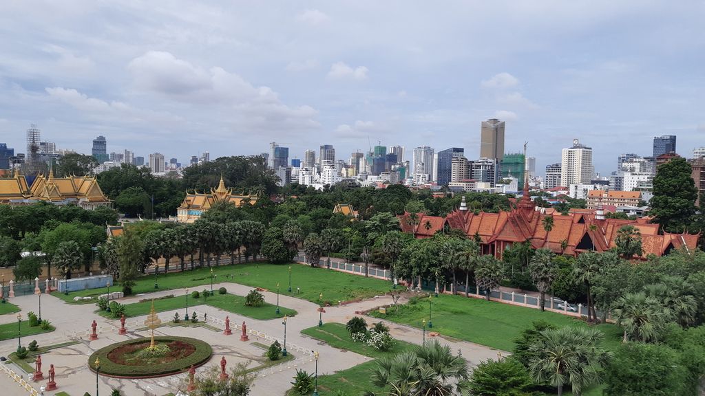 Alun-alun Kota Phnom Penh, Kamboja, dilihat dari atap Hotel Frangipani pada hari Selasa (2/8/2022). Kompleks beratap keemasan adalah istana kerajaan. Di sebelah kanan, bangunan berwarna merah adalah Museum Nasional.