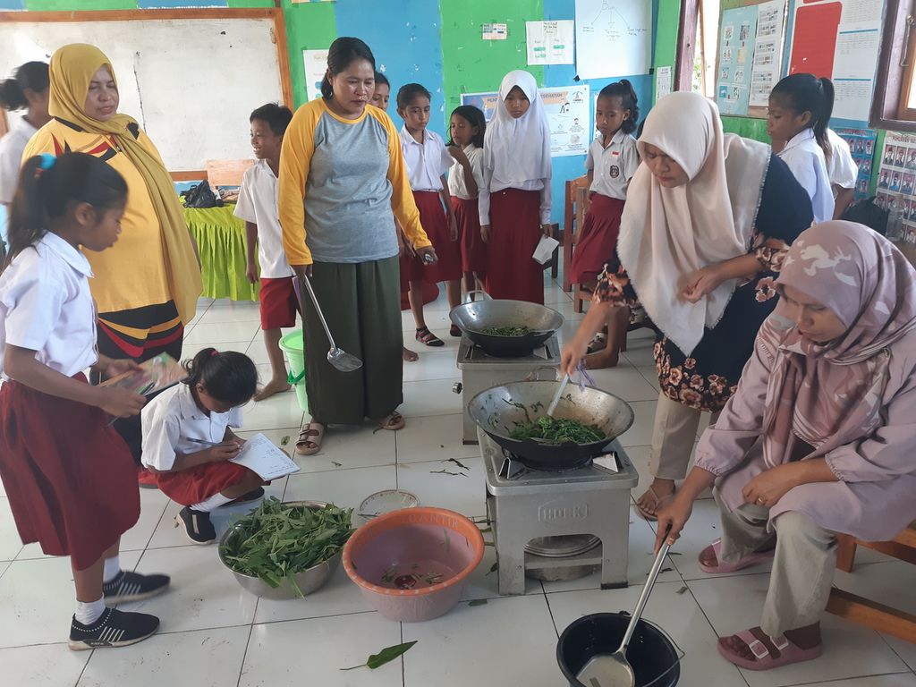 Siswa kelas V SD Negeri Waikelo di Kabupaten Sumba Barat Daya, Nusa Tenggara Timur, mengamati sejumlah orangtua yang memasak sayur kangkung yang baru dipanen dari kebun pangan di sekolah, Selasa (31/5/2022). Para siswa belajar literasi menuliskan resep masakan secara kontekstual dari pengolahan sayur kangkung di sekolah. Sekolah menerapkan pembelajaran yang berpusat pada siswa meskipun belum menerapkan Kurikulum Merdeka. 