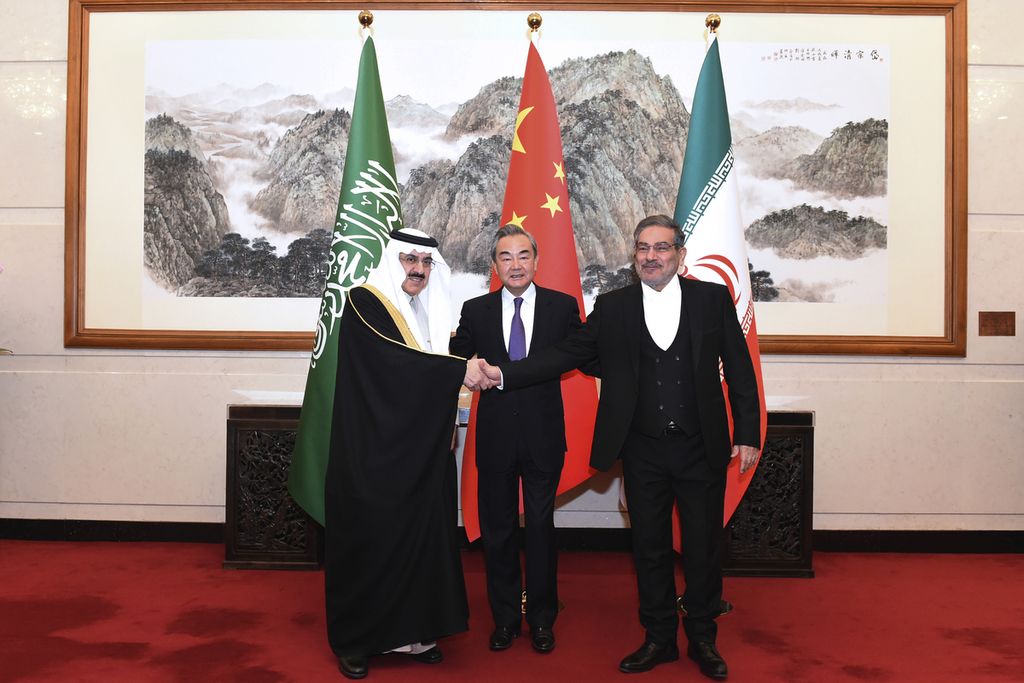 In this photo released by Xinhua News Agency, Ali Shamkhani, the secretary of Iran's Supreme National Security Council, at right, shakes hands with Saudi national security adviser Musaad bin Mohammed al-Aiban, at left, as Wang Yi, China's most senior diplomat, looks on, at center, for a photo during a closed meeting held in Beijing, Saturday, March 11, 2023. Iran and Saudi Arabia agreed Friday to reestablish diplomatic relations and reopen embassies after seven years of tensions. The major diplomatic breakthrough negotiated with China lowers the chance of armed conflict between the Mideast rivals, both directly and in proxy conflicts around the region. 