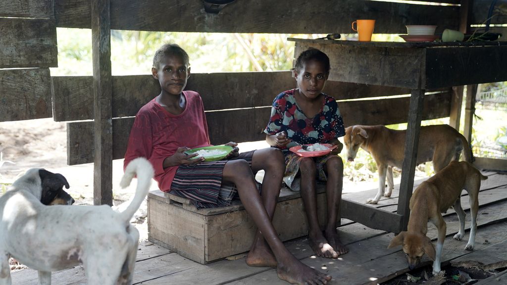 Anak-anak makan nasi putih tanpa lauk atau yang biasa nereka sebut nasi kosong di Kampung Zanegi, Distrik Animha, Kabupaten Merauke, Papua, Kamis (10/11/2022).