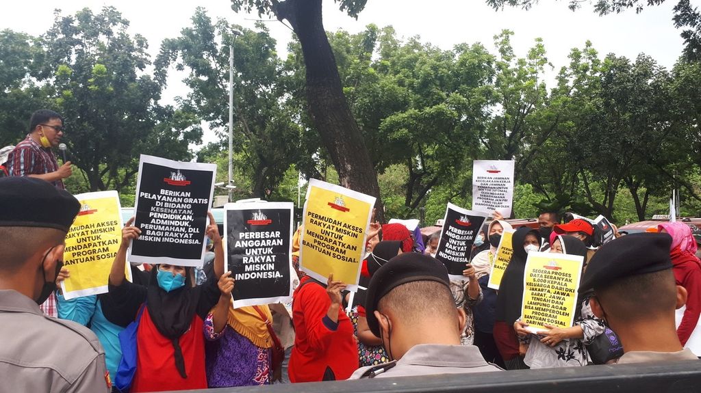Warga berunjuk rasa menuntut bantuan sosial di Kantor Pemerintah Provinsi DKI Jakarta, Jakarta Pusat, Rabu (14/12/2022).