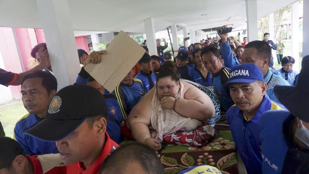 Titi Wati (37), wanita penderita obesitas dengan berat lebih dari 300 kilogram, digotong tim pemadam kebakaran Kota Palangkaraya, Kalimantan Tengah, menuju ruangannya di Rumah Sakit Umum Daerah (RSUD) Doris Sylvanus Palangkaraya, Jumat (11/1/2019). Titi akan menjalani operasi bariatrik.