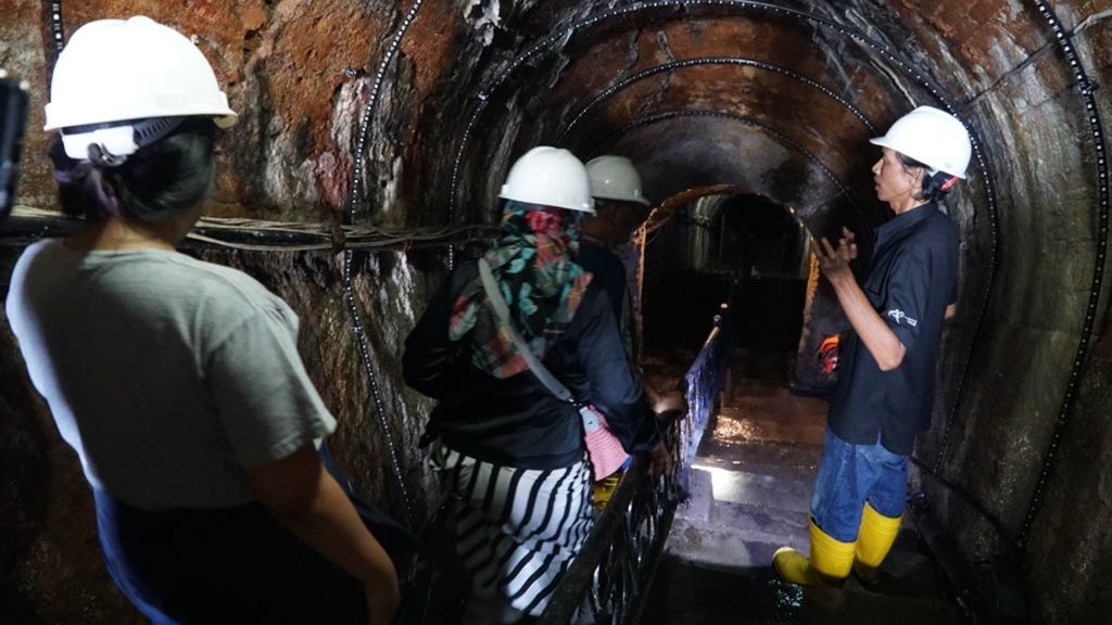 Pemandu wisata (kanan) menjelaskan kepada para pengunjung terkait Lubang Tambang Mbah Soero, salah satu lubang tambang peninggalan Tambang Batubara Ombilin di Sawahlunto, Sumatera Barat, Sabtu (29/6/2019). 