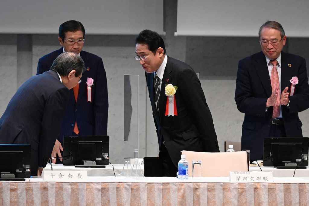 Perdana Menteri Jepang Fumio Kishida (kedua dari kanan) disambut ketika tiba dalam pertemuan Perhimpunan Bisnis Jepang, atau Keidanren, di Tokyo, Senin (26/12/2022). Jepang meningkatkan anggaran pertahanan di tengah kondisi Asia Timur yang kian panas. 