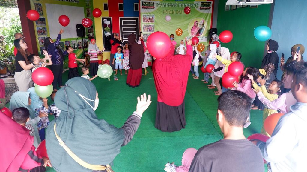 Anak-anak bersama orangtuanya bermain balon dalam kegiatan Kado Pekan Ceria di Kampung Dongeng Intan Kalsel di Sungai Paring, Martapura, Kabupaten Banjar, Kalimantan Selatan, Minggu (19/2/2023).