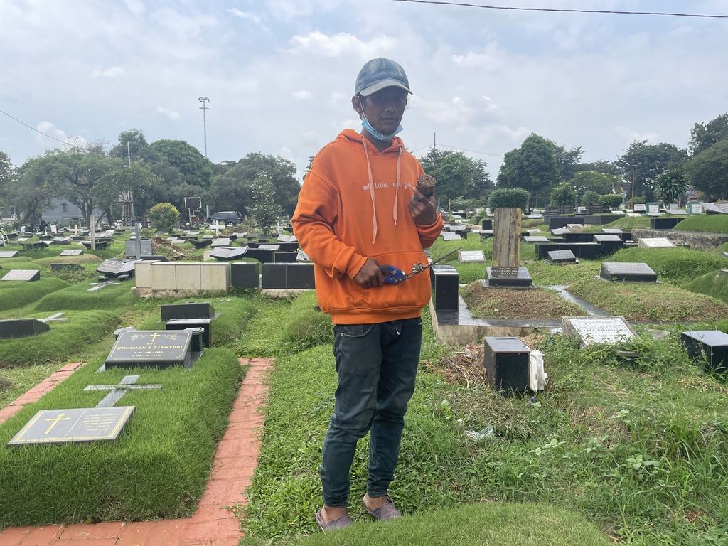 Iqbal Tawakal (32), pembersih makam di Taman Pemakaman Umum Tanah Kusir, Jakarta Selatan, Kamis (16/3/2023).