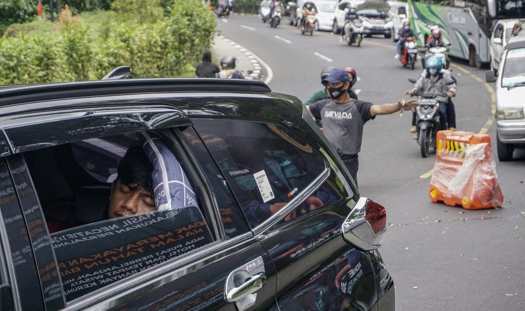 Seorang penumpang kendaraan terlelap di tengah kepadatan antrean kendaraan di sekitar Gunung Mas, Puncak, Kabupaten Bogor, Jawa Barat, bertepatan dengan hari libur Tahun Baru 2022, Sabtu (1/1/2022). 