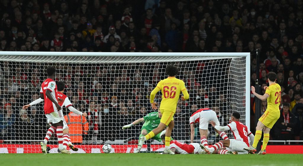 Penyerang Liverpool, Diogo Jota (kanan), melepaskan tembakan yang tidak bisa diantisipasi sejumlah pemain Arsenal untuk membawa Liverpool unggul satu gol pada laga kedua semifinal Piala Liga Inggris, Jumat (21/2/2022) dini hari WIB, di Stadion Emirates. Jota mencetak dua gol untuk membantu Liverpool menang 2-0.