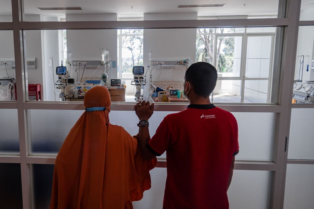 Pasangan suami istri, Eva Nurmala (34) dan Lamhari (39), melihat anak ketiga mereka, Nasifa (2,8), dari balik kaca di ruang <i>pediatric intensive care unit </i>(PICU) atau ruang perawatan intensif khusus anak di Rumah Sakit Badan Pengusahaan Batam, Kota Batam, Kepulauan Riau, Kamis (27/10/2022). Nasifa dirawat di rumah sakit tersebut sejak satu bulan lalu karena gagal ginjal.