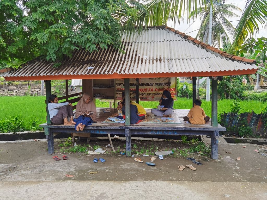 Anak-anak pekerja migran menghabiskan waktu dengan membaca buku di Sekretariat Forum Anak Pandan Wangi di Desa Pandan Wangi, Kecamatan Jerowaru, Kabupaten Lombok Timur, Nusa Tenggara Barat (3/3/2021). Forum itu aktif mendorong pemenuhan hak-hak anak pekerja migran di desa tersebut.