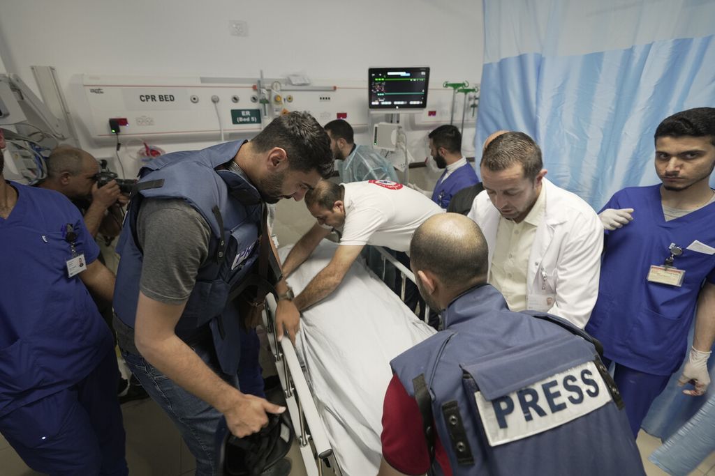 Sejumlah rekan wartawan mengelilingi jenazah Shireen Abu Akleh, jurnalis untuk jaringan Al Jazeera, ke kamar mayat di dalam Rumah Sakit di kota Jenin, Tepi Barat, Palestina, Rabu (11/5/2022). 