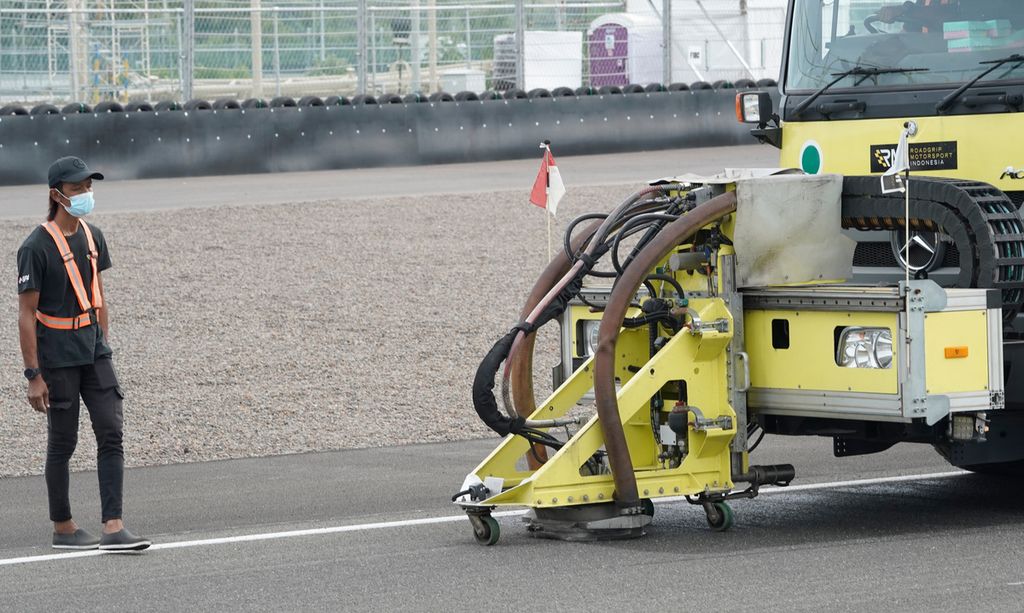 Petugas mengawasi proses pembersihan aspal lintasan dengan mesin khusus, Sabtu (12/2/2022). Sehari sebelumnya, sejumlah pebalap mengeluhkan kondisi lintasan balap. 