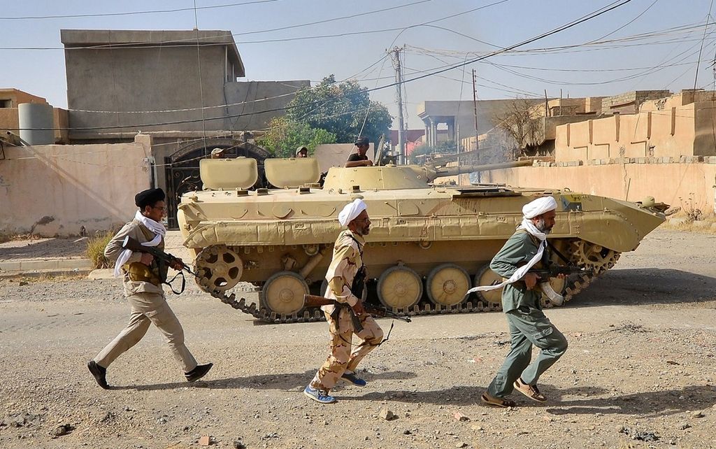 Ilustrasi. Anggota milisi Syiah, Hashed al-Shaabi, berlari di samping tank dalam serangan bersama pasukan Irak di Kota Hawija, Irak, Kamis (5/10). Militer Irak mengklaim telah merebut kota itu dari milisi Negara Islam di Irak dan Suriah (NIIS).