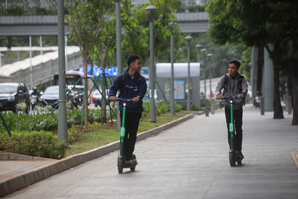Two citizen ride electric scooter on pedestrian in Bendungan Hilir, Central Jakarta, Thursday (14/11/2019). 