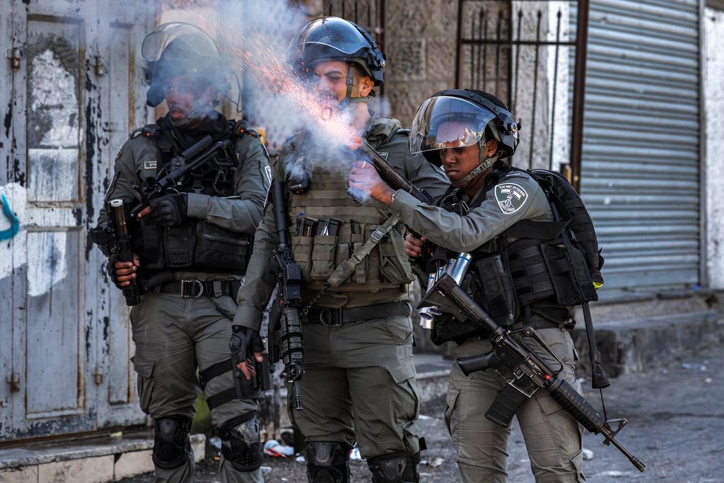 Seorang anggota polisi perbatasan Israel menembakkan gas air mata ke kerumunan ketika tengah berlangsung penghancuran pemukiman warga Palestina di wilayah Issawiya, Jerusalem TImur, Minggu (19/2/2023). 