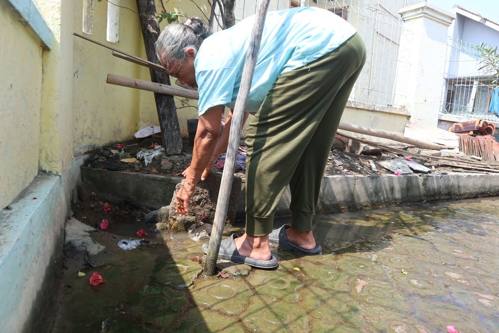 Nuramah (66) menutup saluran drainase untuk mencegah air masuk rumahnya di Blok Balong, Desa Gebang Ilir, Kecamatan Gebang, Kabupaten Cirebon, Jawa Barat, Senin (20/6/2022). Daerah tersebut kerap terdampak banjir rob saat air laut pasang. 