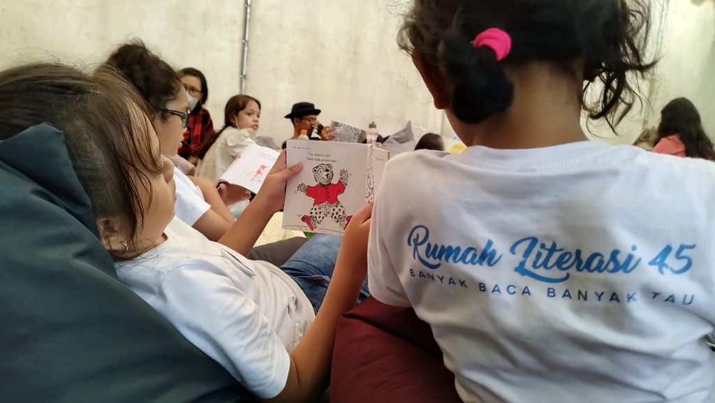 Seorang anak tengah asyik membaca buku cerita anak dalam acara bertajuk membaca dan menulis bersama di kawasan Cibubur, Kecamatan Ciracas, Jakarta Timur, Minggu (29/1/2023).