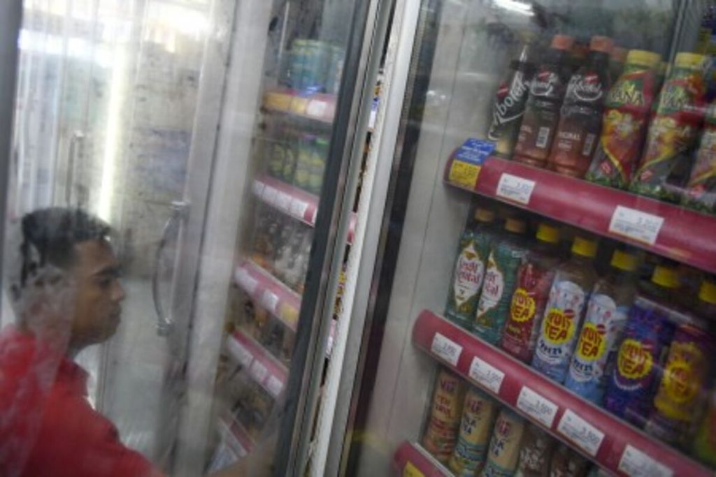 Karyawan menyusun minuman kemasan di salah satu gerai Alfamart di Palembang, Sumatera Selatan, Kamis (20/2/2020).