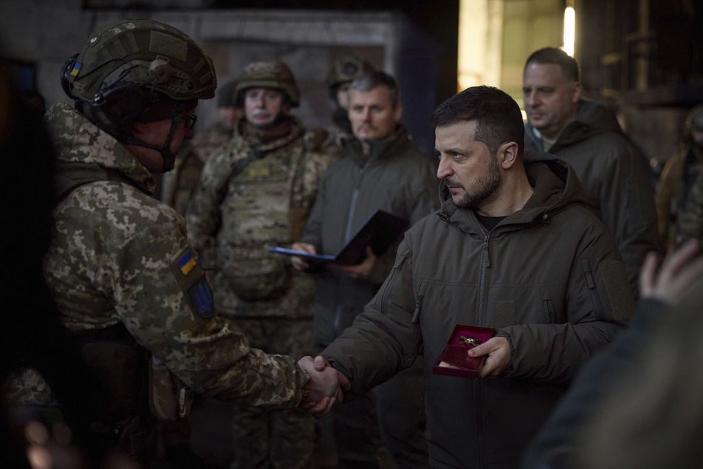 Presiden Ukraina Volodymyr Zelenskyy menyerahkan medali kepada pasukan Ukraina di Bakhmut, Donetsk, pada Selasa (20/12/2022). Pada Rabu (21/12/2022), Zelenskyy dilaporkan akan berada di Amerika Serikat.