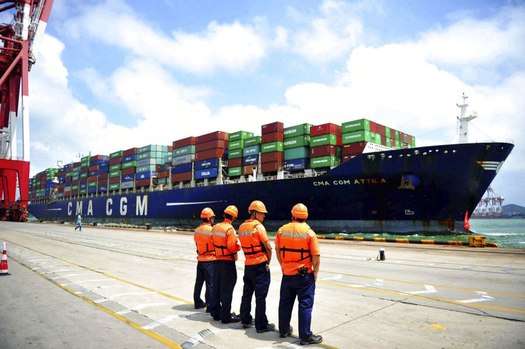 Dalam foto tanggal 8 Agustus 2017 ini, beberapa pekerja pelabuhan menanti untuk memulai pekerjaan pada kapal kontainer yang berlabuh di pelabuhan Qingdao, Provinsi Shandong, China timur. 