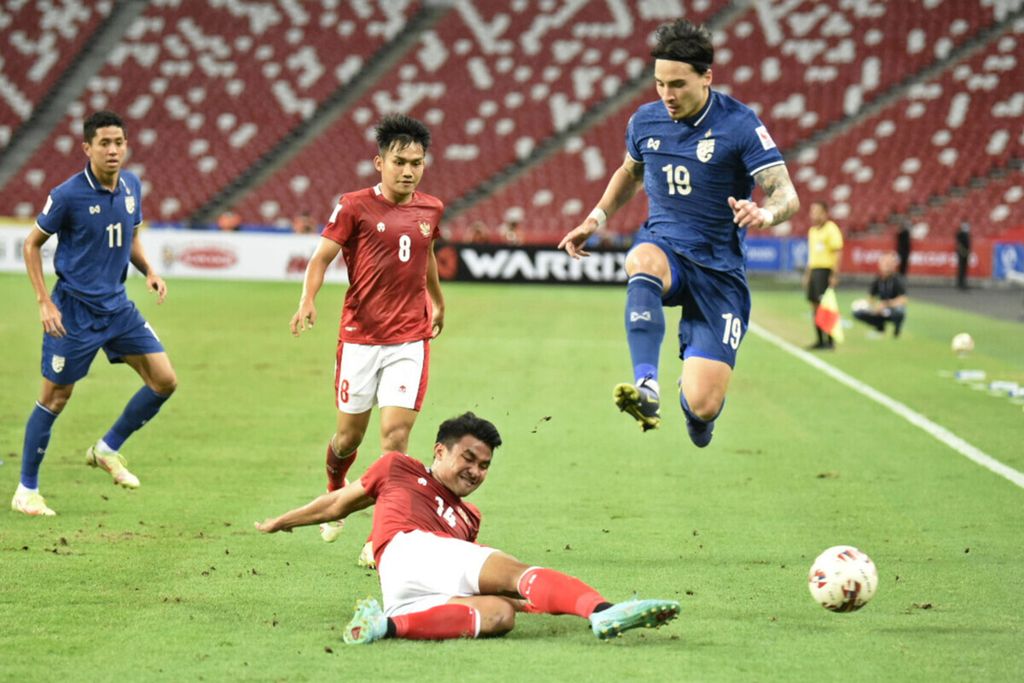 Pemain Indonesia, Asnawi Mangkualam (kedua kanan), mencoba menekel pemain Thailand, Tristan Do (kanan), dalam laga pertemuan pertama final Piala AFF 2020 di Stadion Nasional Singapura, Rabu (29/12/2021).
