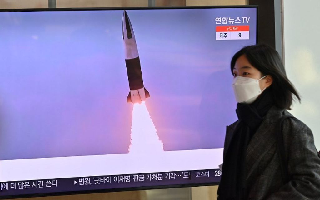 Seorang wanita berjalan melewati layar televisi yang menyangkan siarang ulang uji coba rudal Korea Utara, di sebuah stasiun kereta api di Seoul, Korea Selatan, Kamis (20/1/2022), setelah Korut mengisyaratkan akan melanjutkan uji coba senjata nuklir dan rudak jarak jauhnya.