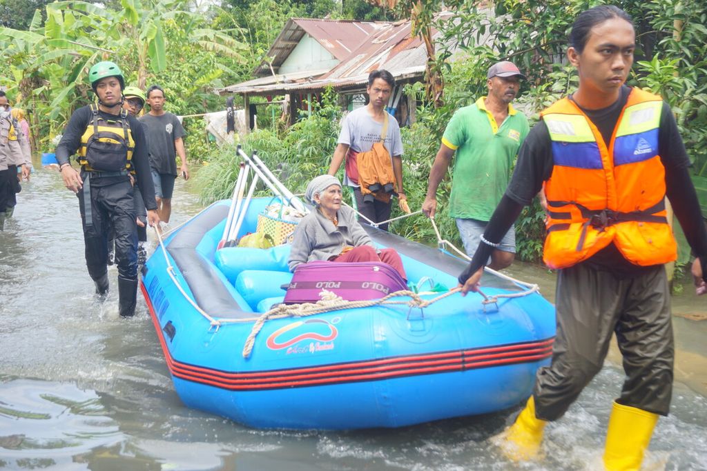 Sukarelawan mengevakuasi lansia di tengah banjir yang merendam Desa Nusadadi, Kecamatan Sumpiuh, Banyumas, Jawa Tengah, Jumat (18/3/2022). Sekitar 20 warga mengungsi ke tempat aman.