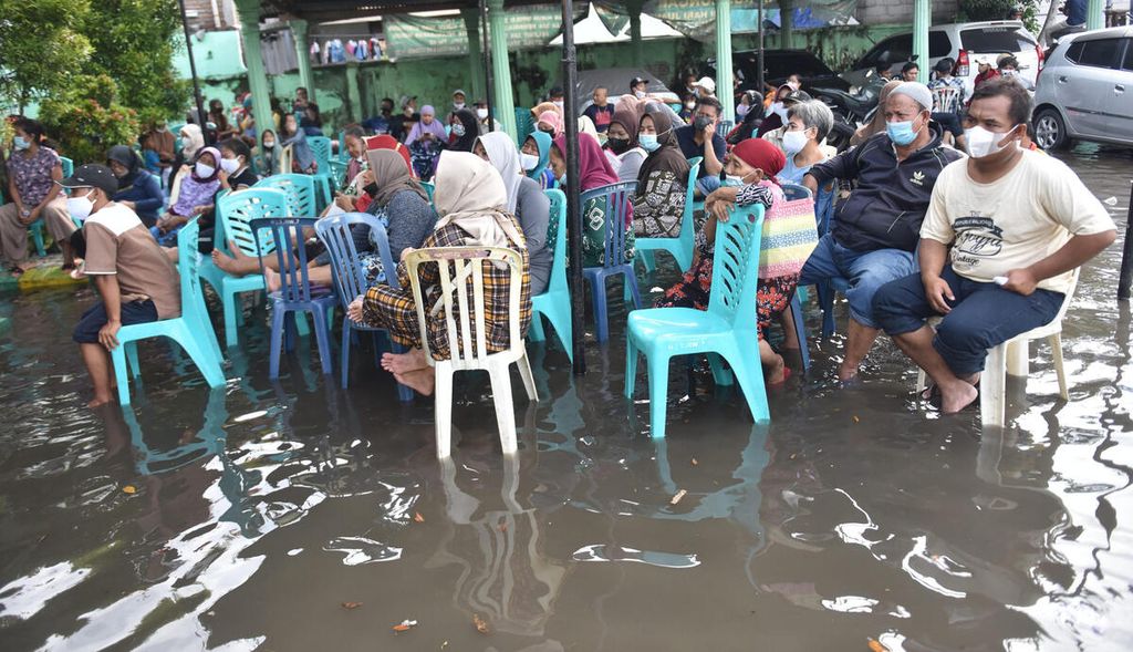 Ilustrasi. Warga antre mendapatkan bantuan langsung tunai (BLT) minyak goreng saat banjir rob di halaman Markas Koramil 0830/01 Krembangan, Kota Surabaya, Jawa Timur, kamis (19/5/2022). 