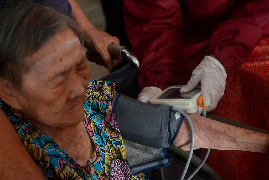 Petugas kesehatan memeriksa kesehatan salah satu warga lanjut usia yang akan mendapatkan vaksin lanjutan di Gang Pinggir, Kota Semarang, Jawa Tengah, Senin (7/3/2022).