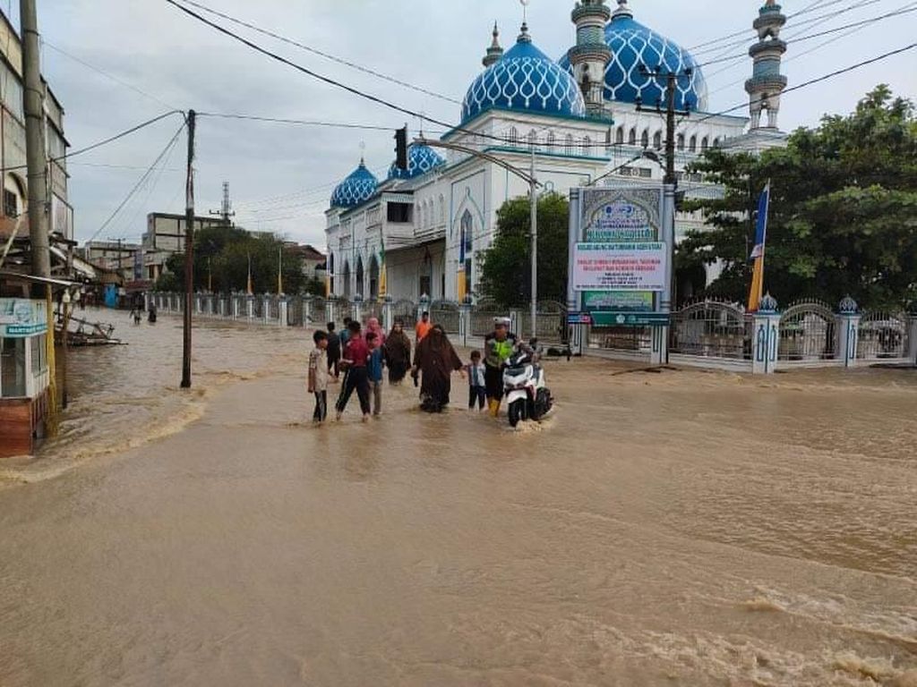 Jalan nasional di Kota Lhoksukon, Kabupaten Aceh Utara, Aceh, Kamis (6/10/2022), tergenang banjir. Permukiman warga juga tidak luput dari genangan sehingga membuat warga terpaksa mengungsi